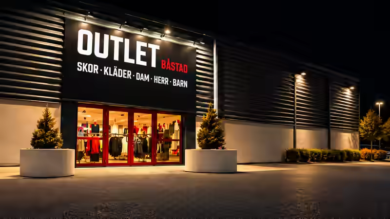 Outlet Båstad storefront and illuminated entrance in the evening